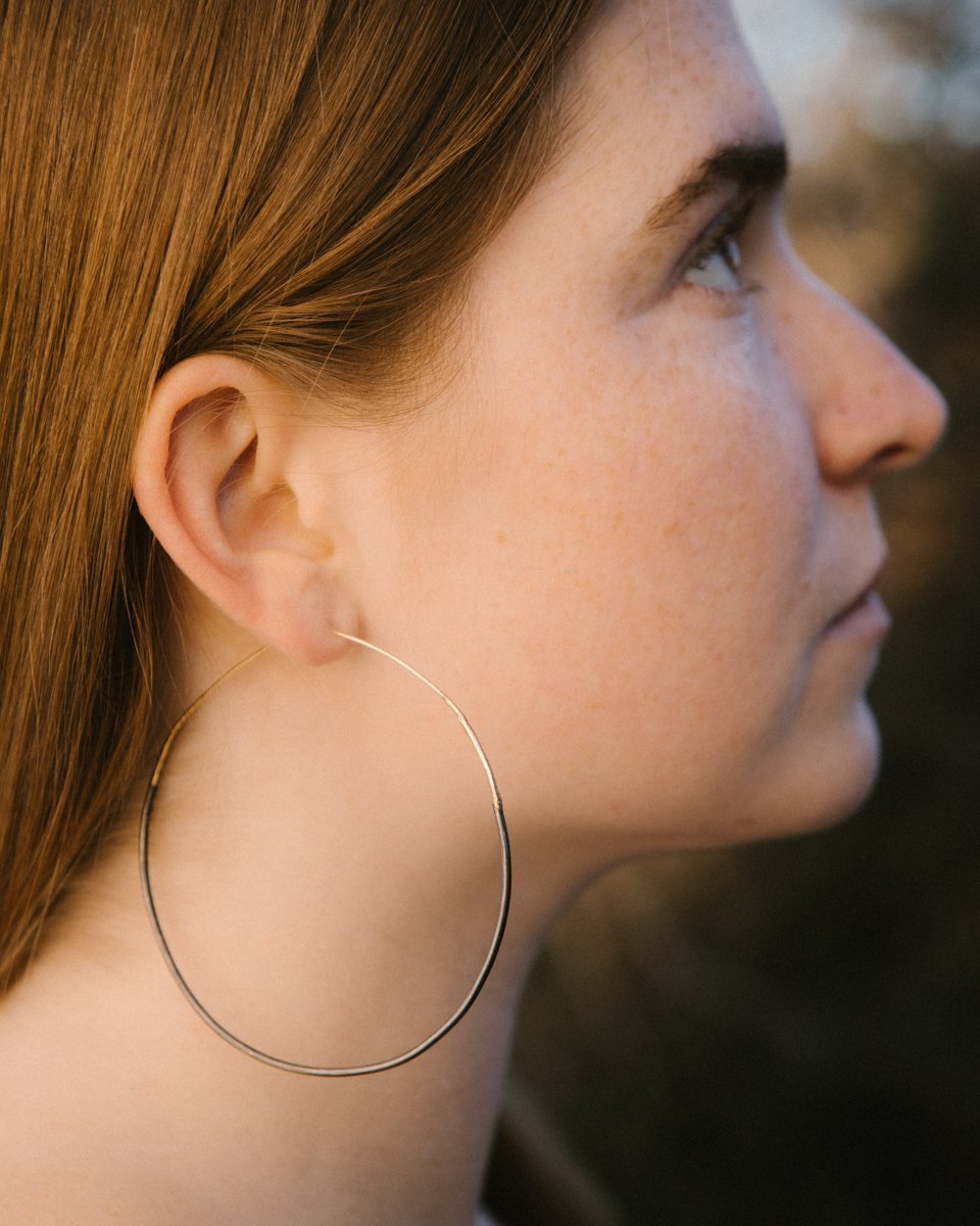 Lady wearing large mixed gold and silver ombre hoops