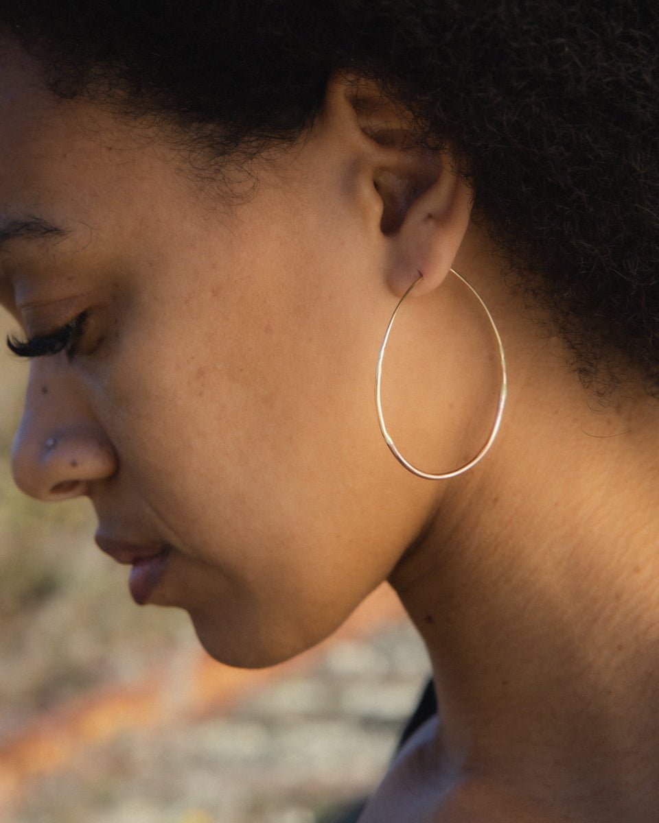 Lady wearing small gold ombre hoop earrings