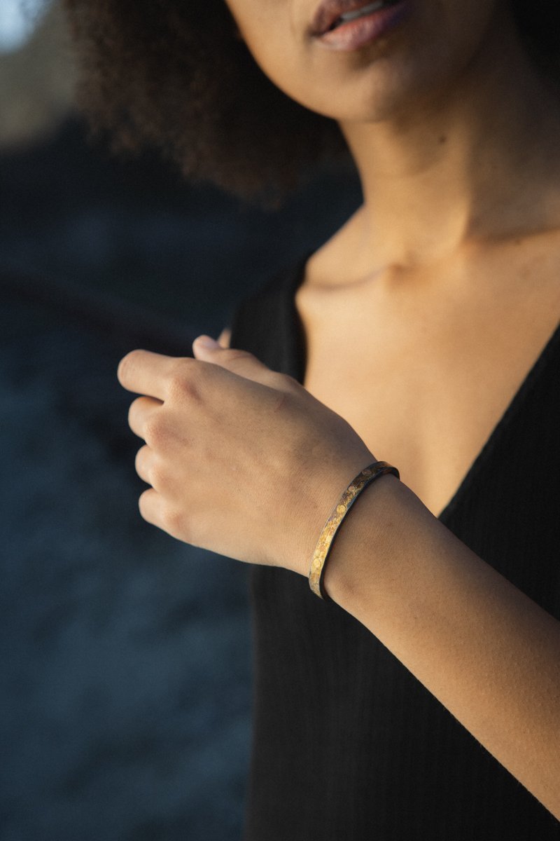 Lady wearing heavy gold and silver cuff